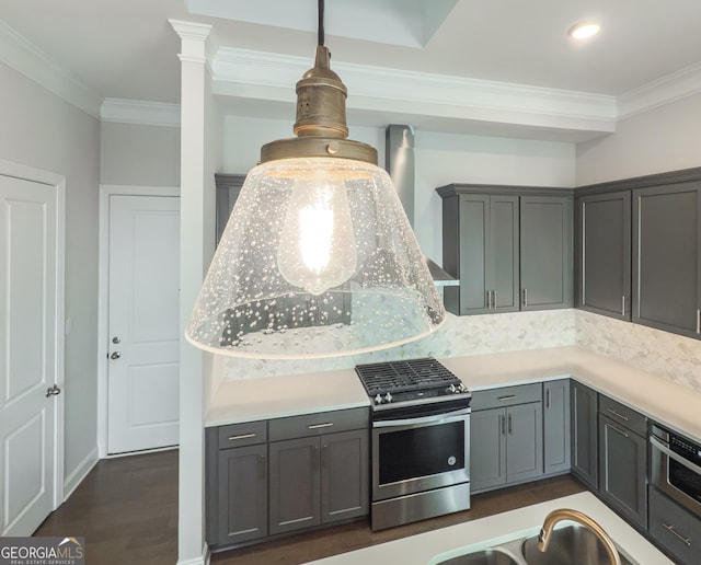 kitchen featuring light countertops, hanging light fixtures, gray cabinetry, and gas range