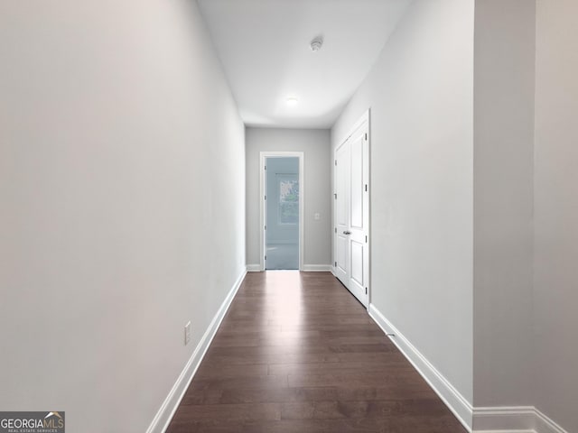 hall featuring dark wood-style floors and baseboards