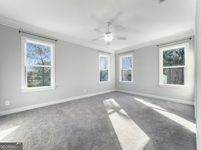 empty room featuring baseboards, carpet, a ceiling fan, and crown molding