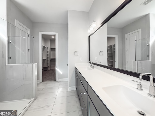 bathroom with a spacious closet, a sink, and visible vents