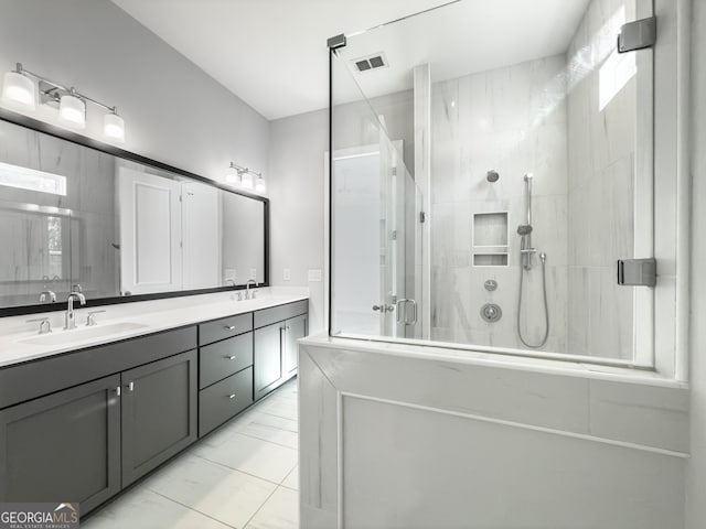 bathroom with double vanity, a stall shower, visible vents, and a sink