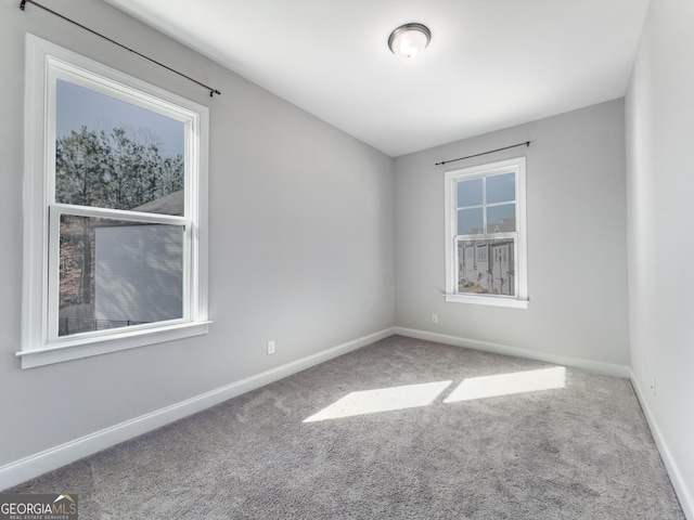 carpeted empty room with baseboards