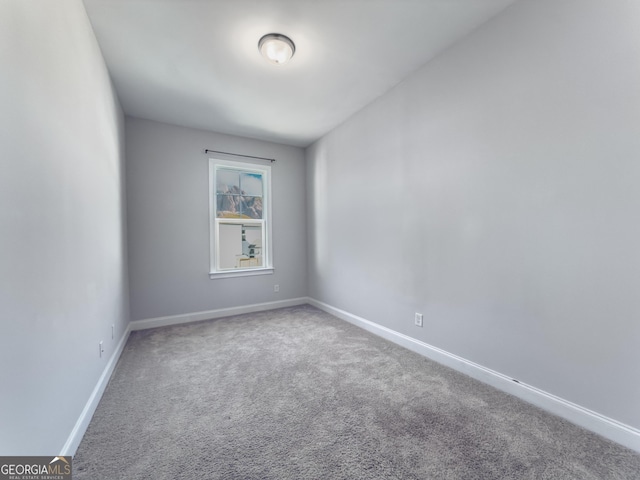 carpeted spare room featuring baseboards