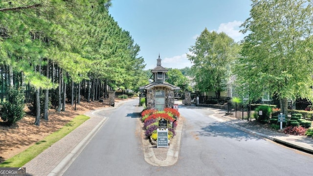 view of street with a gate and curbs