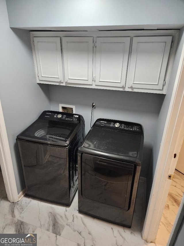 washroom with cabinets and washing machine and clothes dryer