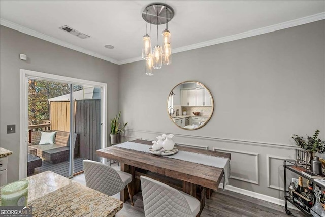 dining room featuring crown molding, dark wood-type flooring, and an inviting chandelier