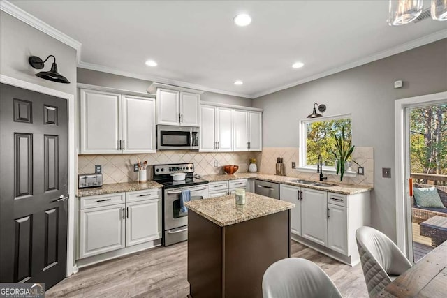 kitchen featuring white cabinets, stainless steel appliances, a wealth of natural light, and sink