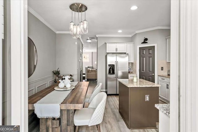 kitchen featuring white cabinets, a center island, light hardwood / wood-style floors, and stainless steel refrigerator with ice dispenser