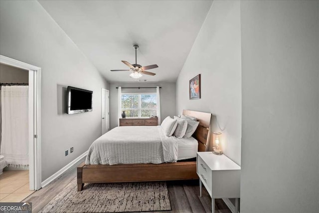 bedroom with ceiling fan, lofted ceiling, and light wood-type flooring