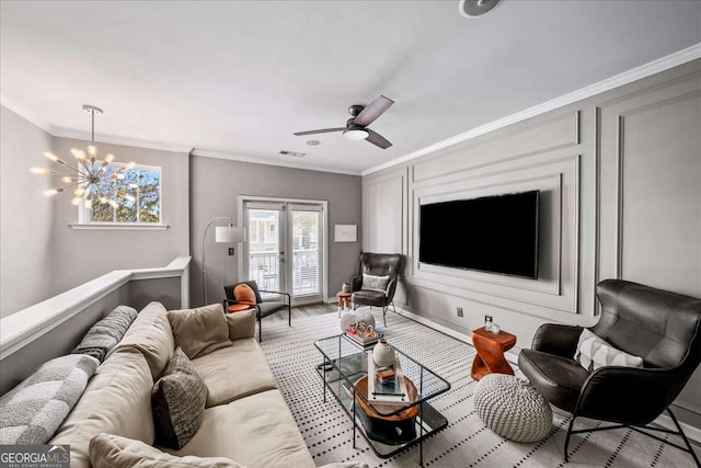 living room featuring ceiling fan with notable chandelier and ornamental molding