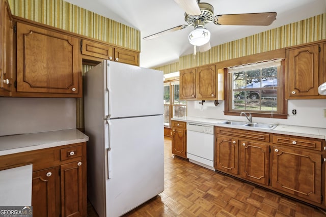 kitchen with ceiling fan, sink, parquet flooring, vaulted ceiling, and white appliances