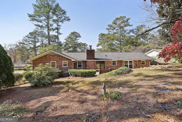 rear view of property with a lawn and central AC