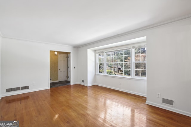 empty room with wood-type flooring and ornamental molding