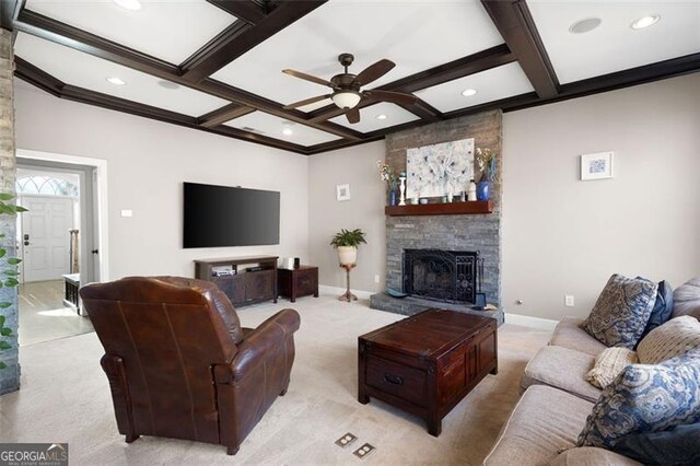 living room featuring light carpet, a stone fireplace, ceiling fan, and coffered ceiling