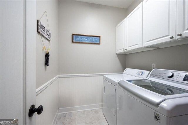 laundry room featuring separate washer and dryer and cabinets