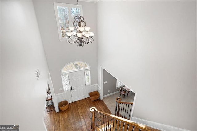 entryway featuring hardwood / wood-style floors, a notable chandelier, and a high ceiling