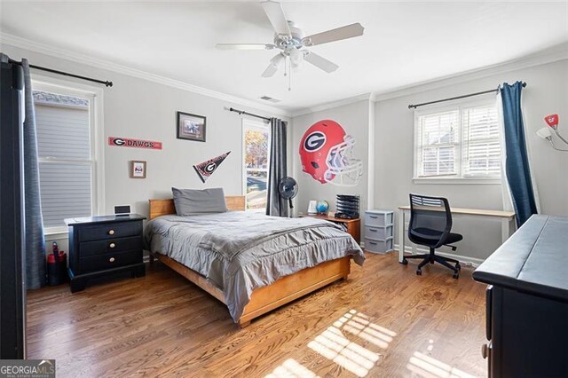 bedroom featuring hardwood / wood-style floors, ceiling fan, and ornamental molding