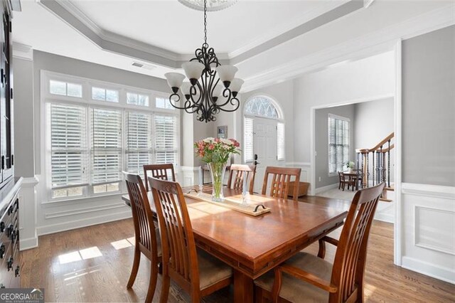 dining area with light wood-type flooring, an inviting chandelier, and a wealth of natural light