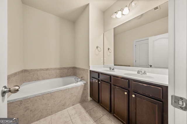 full bath featuring tile patterned floors, visible vents, a sink, double vanity, and a bath