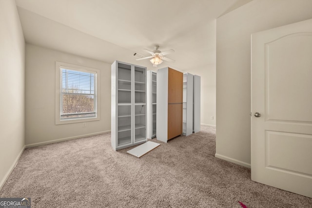 interior space with baseboards, carpet, and a ceiling fan