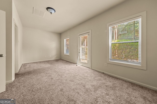 unfurnished bedroom with access to outside, carpet flooring, baseboards, and visible vents