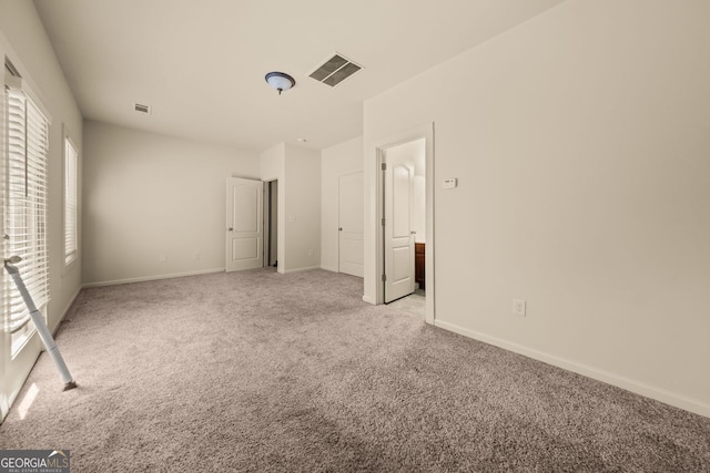 unfurnished bedroom featuring visible vents, light colored carpet, and baseboards