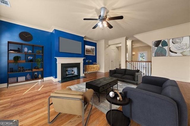 living room with hardwood / wood-style floors, ceiling fan, and crown molding