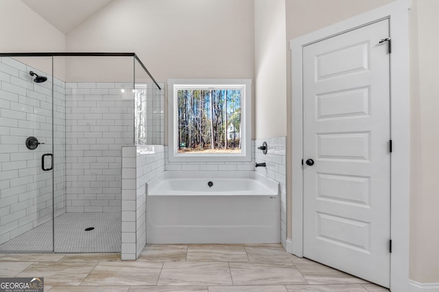 full bath with vaulted ceiling, a stall shower, and a bath