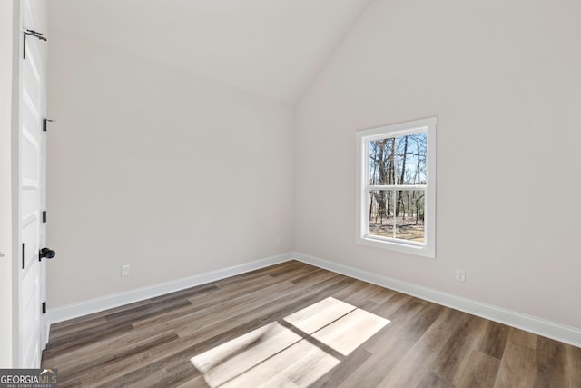 additional living space featuring lofted ceiling, baseboards, and wood finished floors