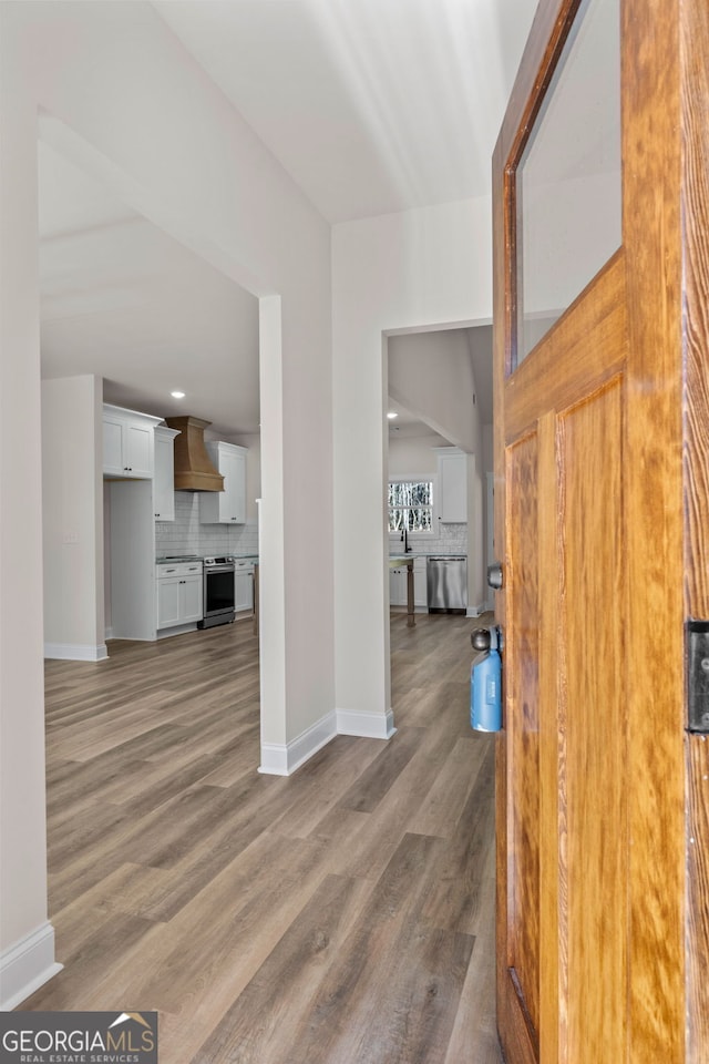 foyer entrance with wood finished floors and baseboards