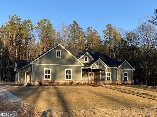 view of front of property featuring an attached garage, brick siding, driveway, and a front lawn