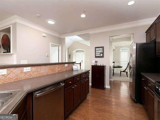 kitchen with dark wood-type flooring, decorative backsplash, ornamental molding, appliances with stainless steel finishes, and dark brown cabinetry