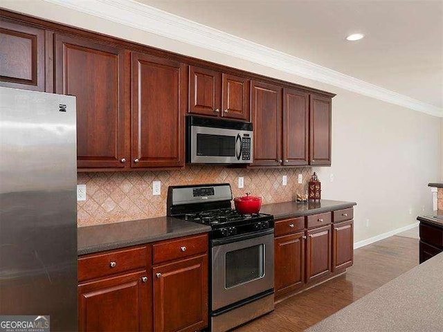 kitchen featuring decorative backsplash, crown molding, dark wood-type flooring, and stainless steel appliances