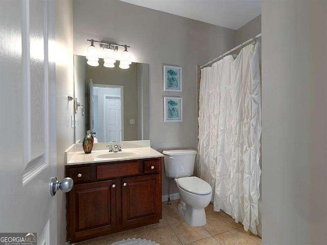 bathroom featuring tile patterned flooring, vanity, toilet, and curtained shower