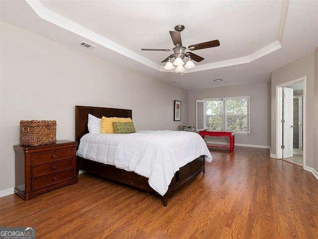 bedroom featuring wood-type flooring, a tray ceiling, ceiling fan, and ornamental molding