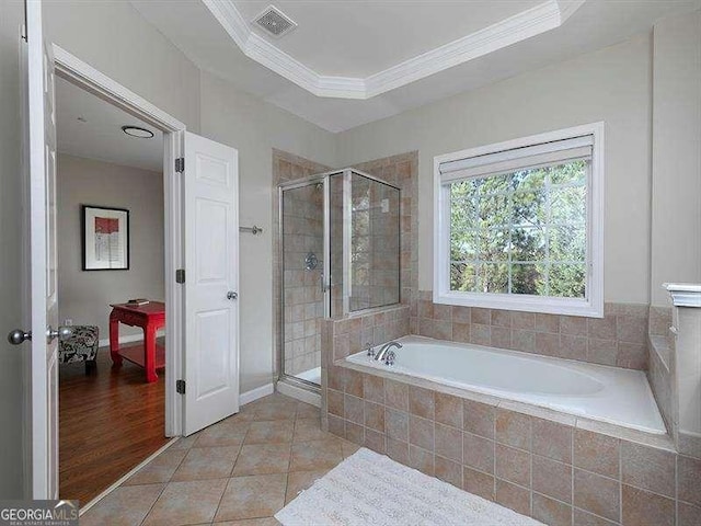 bathroom featuring tile patterned flooring, a raised ceiling, crown molding, and independent shower and bath