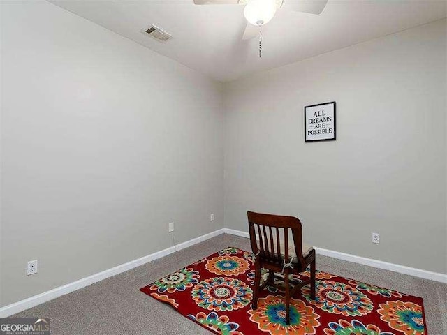 living area featuring carpet flooring and ceiling fan