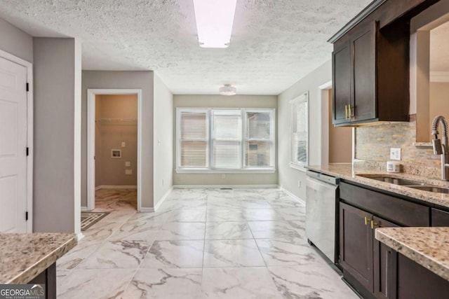 kitchen with decorative backsplash, light stone counters, dark brown cabinetry, sink, and dishwasher