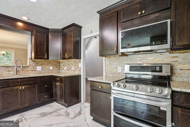 kitchen featuring backsplash, sink, light stone countertops, ornamental molding, and appliances with stainless steel finishes