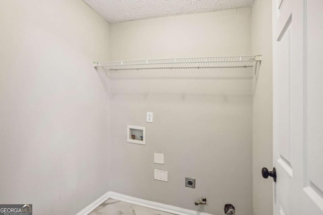 laundry area featuring electric dryer hookup, gas dryer hookup, a textured ceiling, and hookup for a washing machine