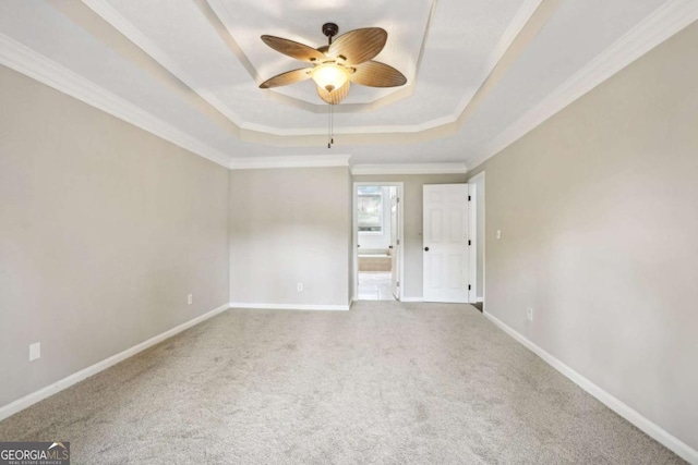 unfurnished bedroom with carpet, ceiling fan, a raised ceiling, and ornamental molding