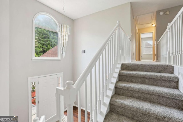 stairway featuring wood-type flooring and a chandelier