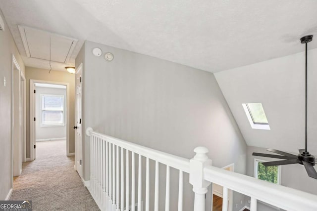 hallway with light colored carpet and lofted ceiling