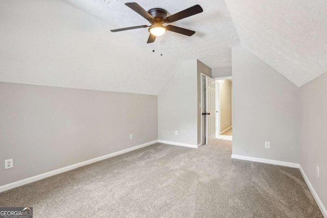 bonus room with carpet, a textured ceiling, vaulted ceiling, and ceiling fan