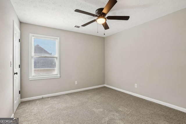 spare room featuring ceiling fan, carpet, and a textured ceiling