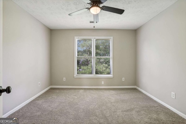 carpeted spare room with a textured ceiling and ceiling fan