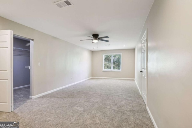 unfurnished bedroom featuring ceiling fan, light carpet, and a closet