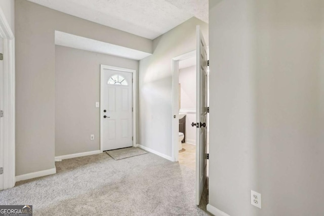 carpeted entryway with a textured ceiling