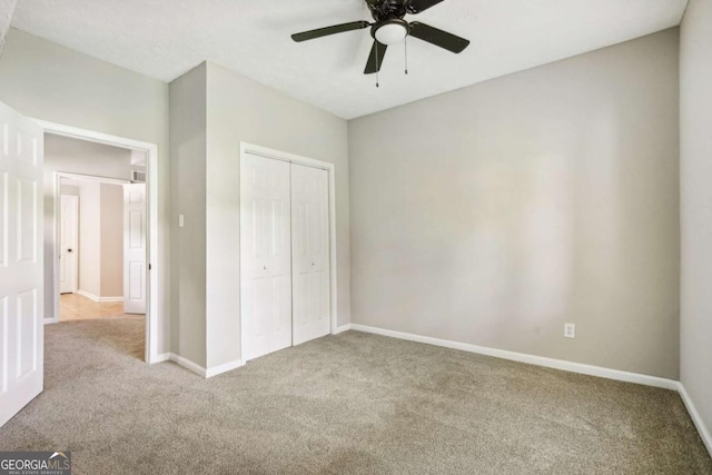 unfurnished bedroom featuring light carpet, a closet, and ceiling fan