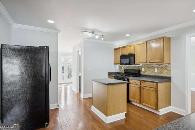 kitchen featuring tasteful backsplash, crown molding, a center island, dark hardwood / wood-style flooring, and black appliances